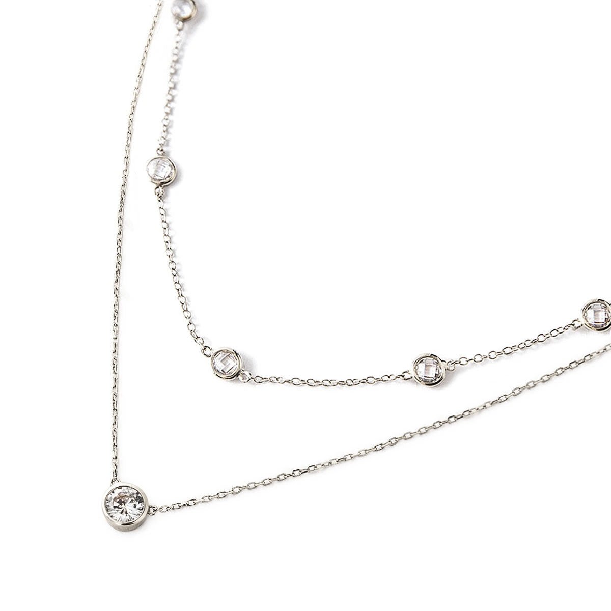 Sterling silver station chain and solitaire pendant duo with clear stones, on a white background