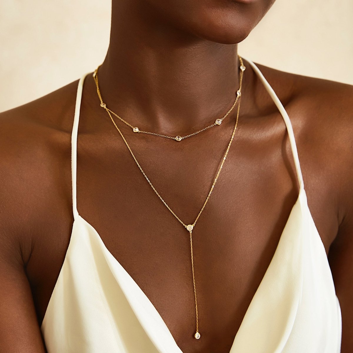 Gold vermeil layered choker with clear stones and a Y-drop, shown on a model's neckline