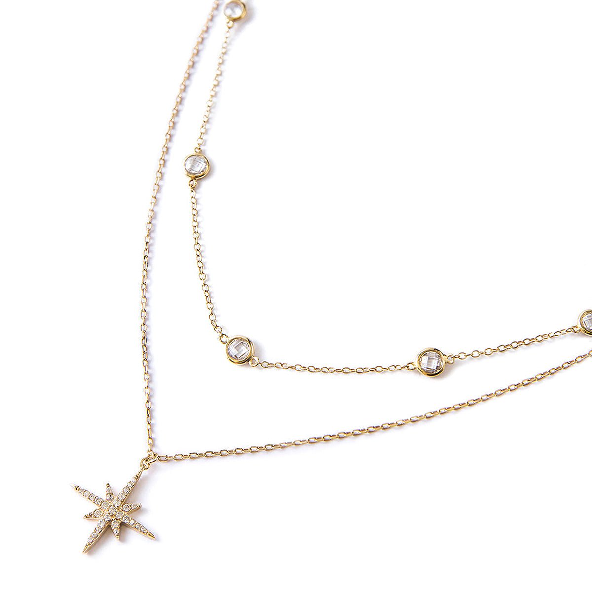 Gold vermeil layered necklace duo with a pavé star pendant and round clear stones, on a white background
