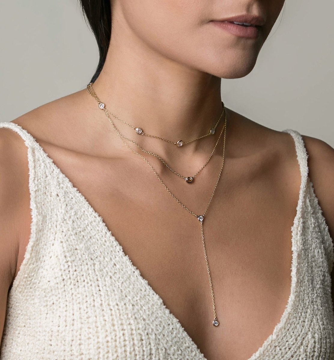 Gold vermeil zirconia station and lariat necklaces layered, shown on a model's neckline