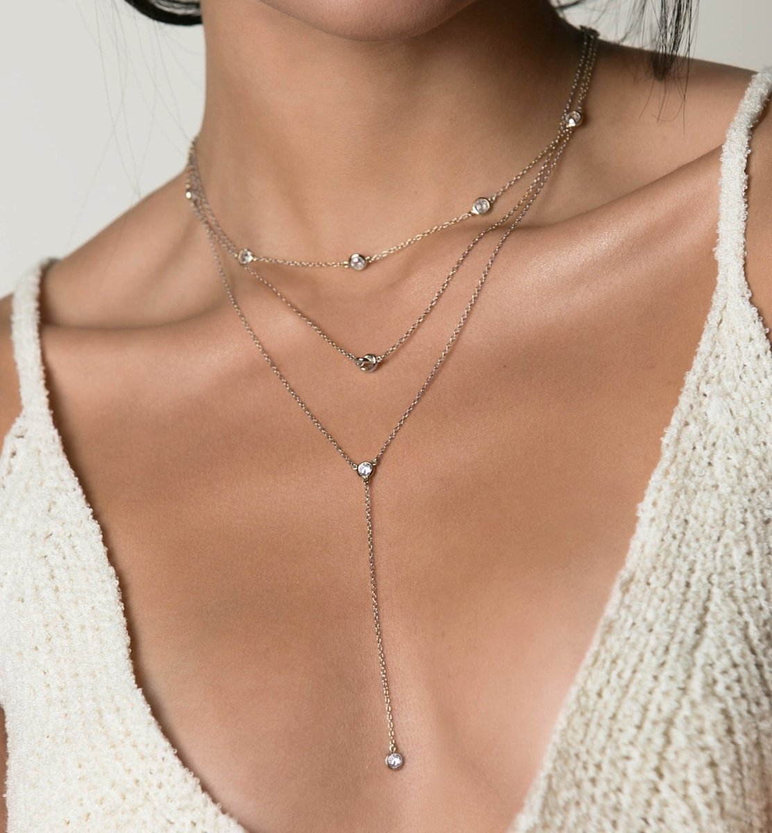 Sterling silver zirconia station and lariat necklaces layered, shown on a model's neckline