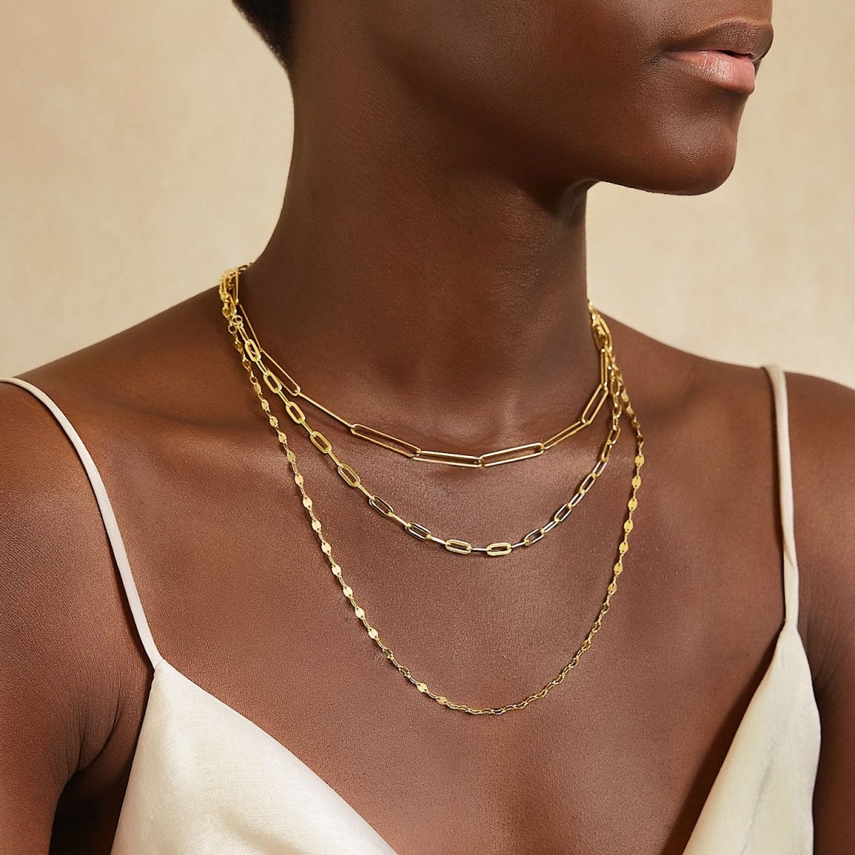 Gold vermeil paperclip chain necklace layered with finer chains on a model's neckline
