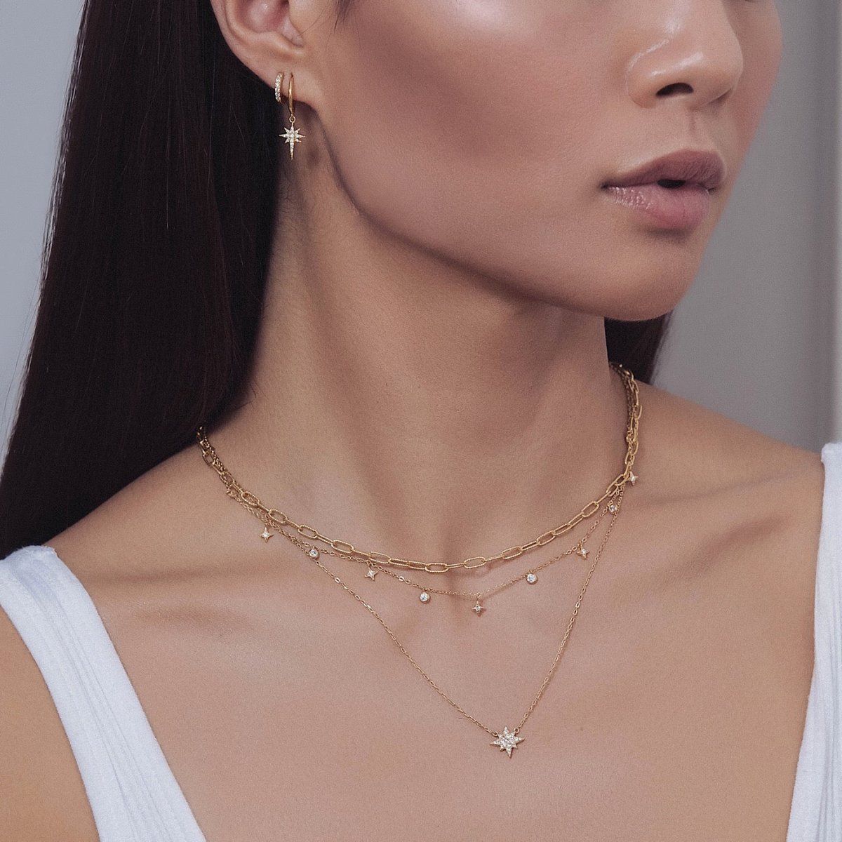Gold vermeil oval link chain necklace layered with chains, shown on a model's neckline