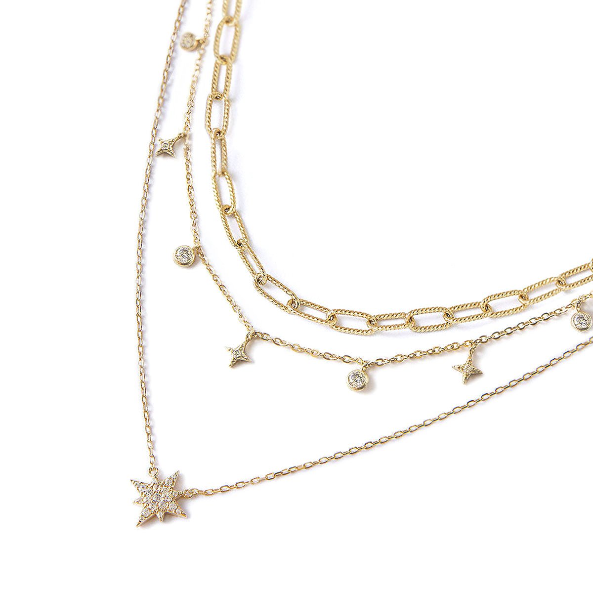 Gold vermeil layered chain trio with starburst and clear crystal charms, on a white background