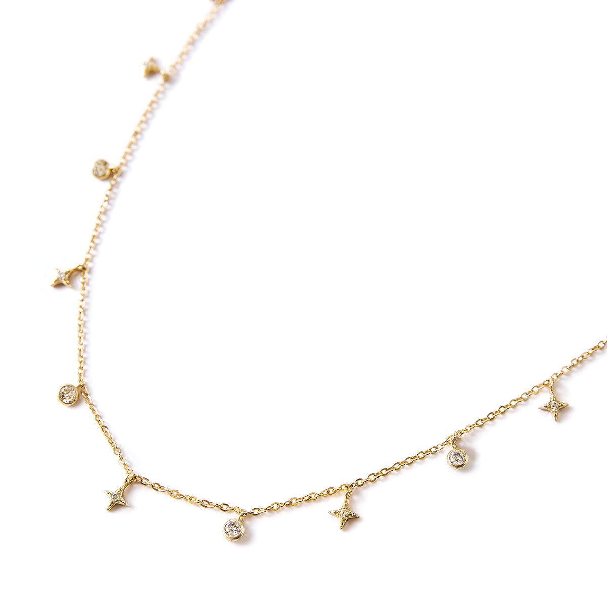 Gold vermeil star dangle necklace with white zirconia stars and bezel charms, on a white background