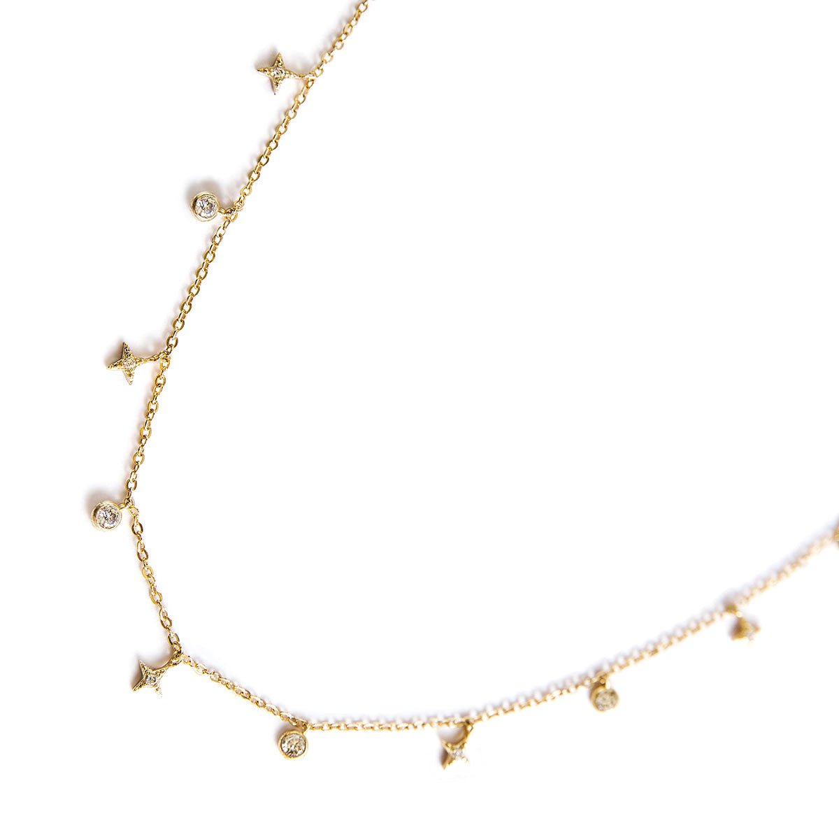 Gold vermeil necklace with star charms and round zirconia drops, close-up on a white background
