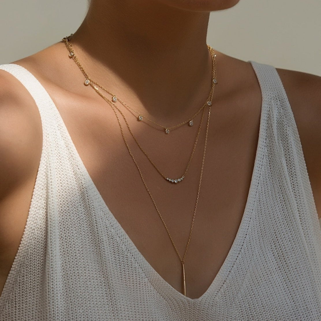 Gold vermeil needle necklace spike bar pendant, shown layered on a model's neckline