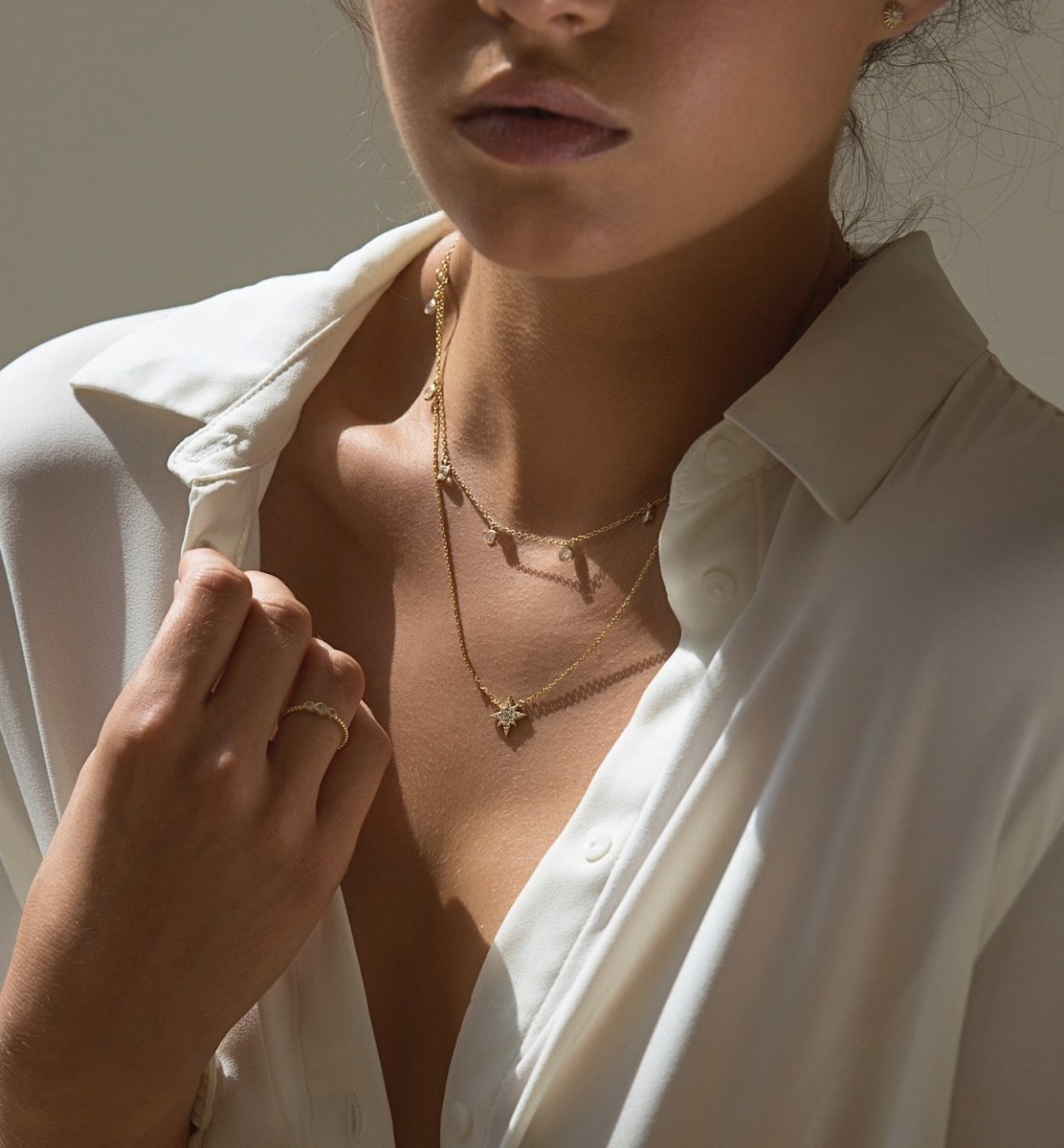 Gold vermeil layered choker duo with clear drops, starburst pendant and a chain ring, shown on a model
