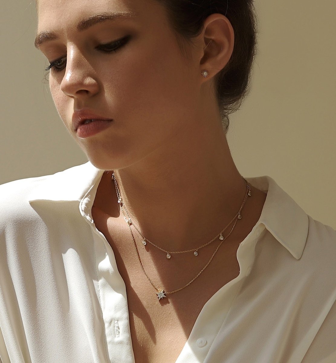 Gold vermeil starburst layered choker duo with clear stone drops, shown on a model's neckline