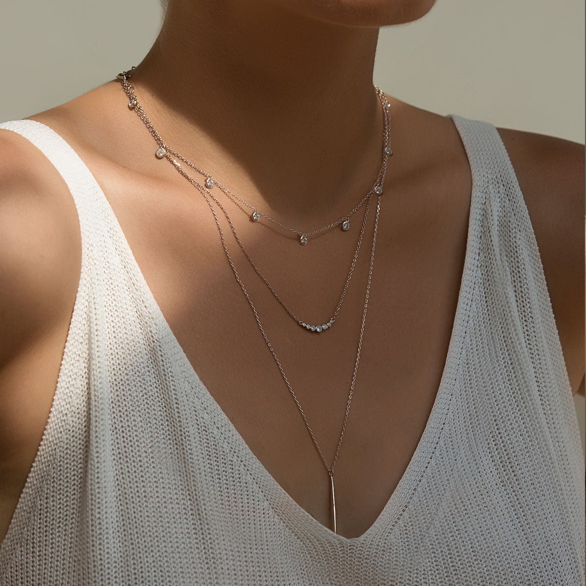 Sterling silver needle necklace spike bar pendant, shown layered on a model's neckline