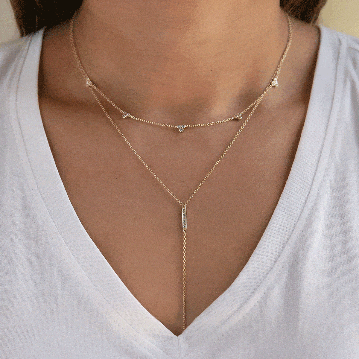 Animation of the gold vermeil clover bar lariat layered duo with clear stones
