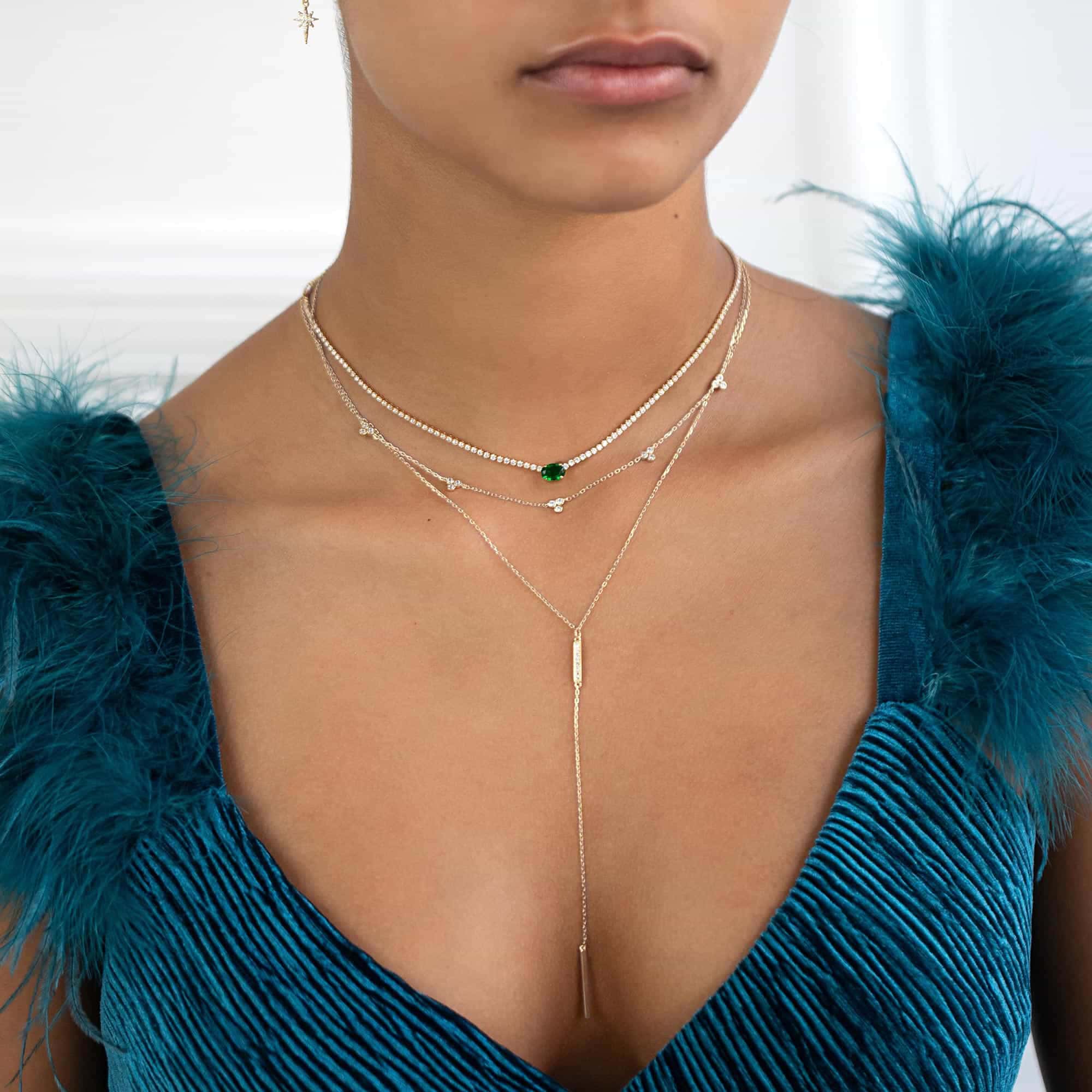 Sterling silver clover bar lariat with a clear-stone bar drop, shown on a model's neckline