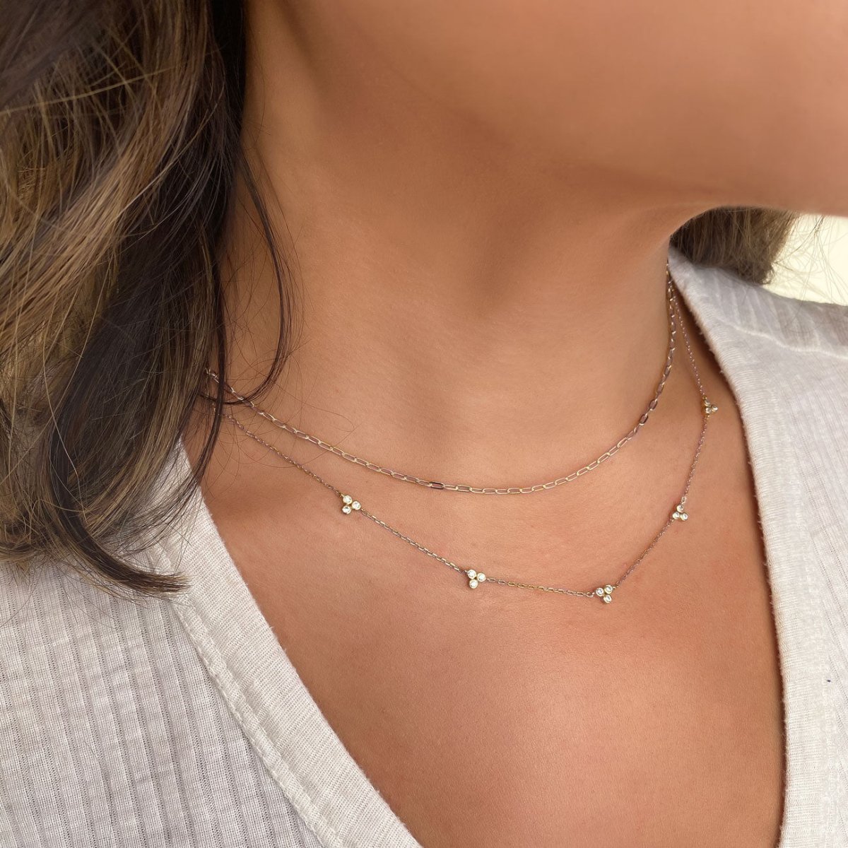 Sterling silver link chain necklace shown layered on a model's neckline