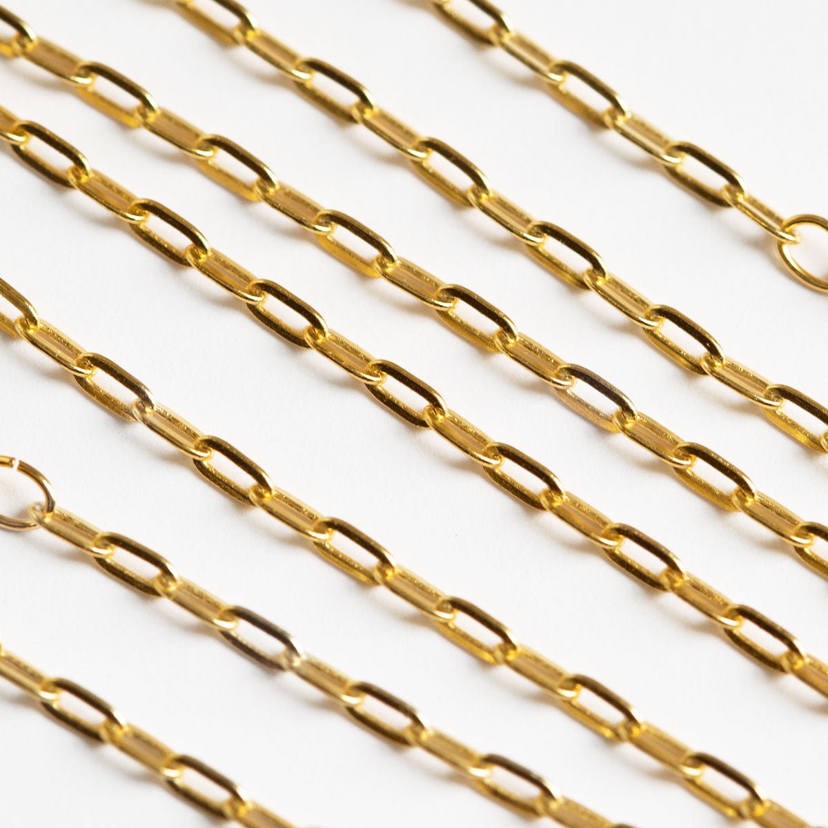 Gold vermeil paperclip link chain, close-up detail on a white background