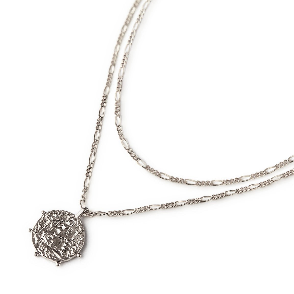 Sterling silver layered necklace duo with a figaro chain and a textured coin pendant, on a white background