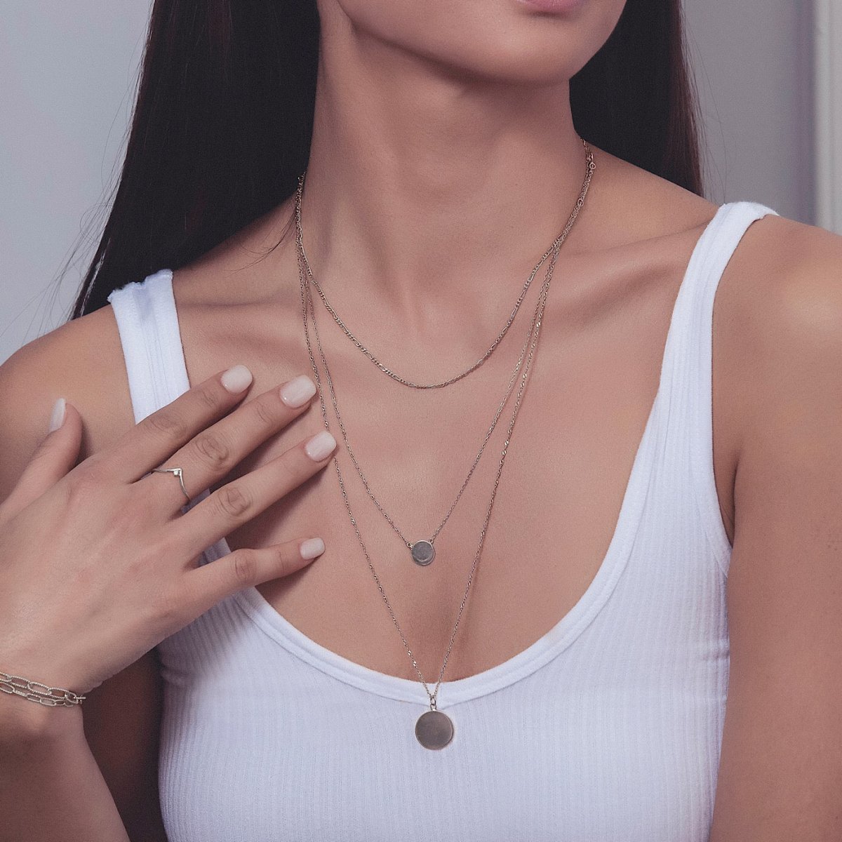 Sterling silver disc necklace shown layered on a model's neckline with a small round disc pendant