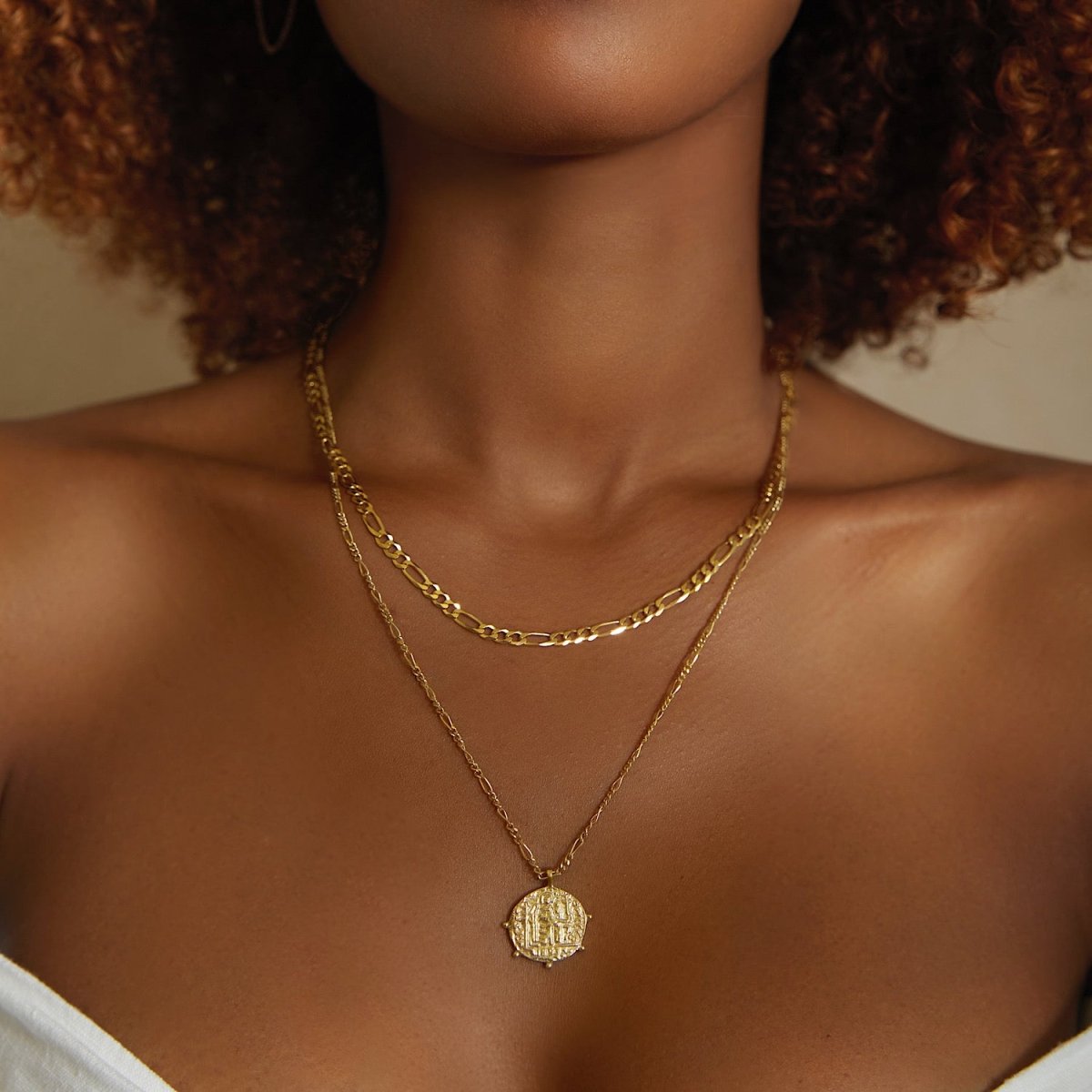 Gold vermeil Grecian coin pendant on a figaro chain, shown layered on a model's neckline
