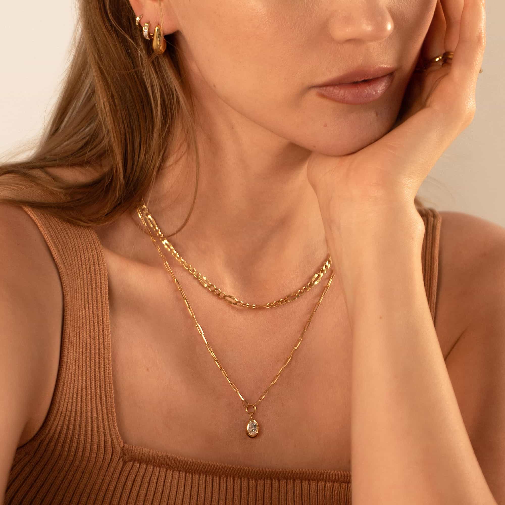 Gold vermeil oval zirconia drop pendant on a paperclip chain, shown layered on a model