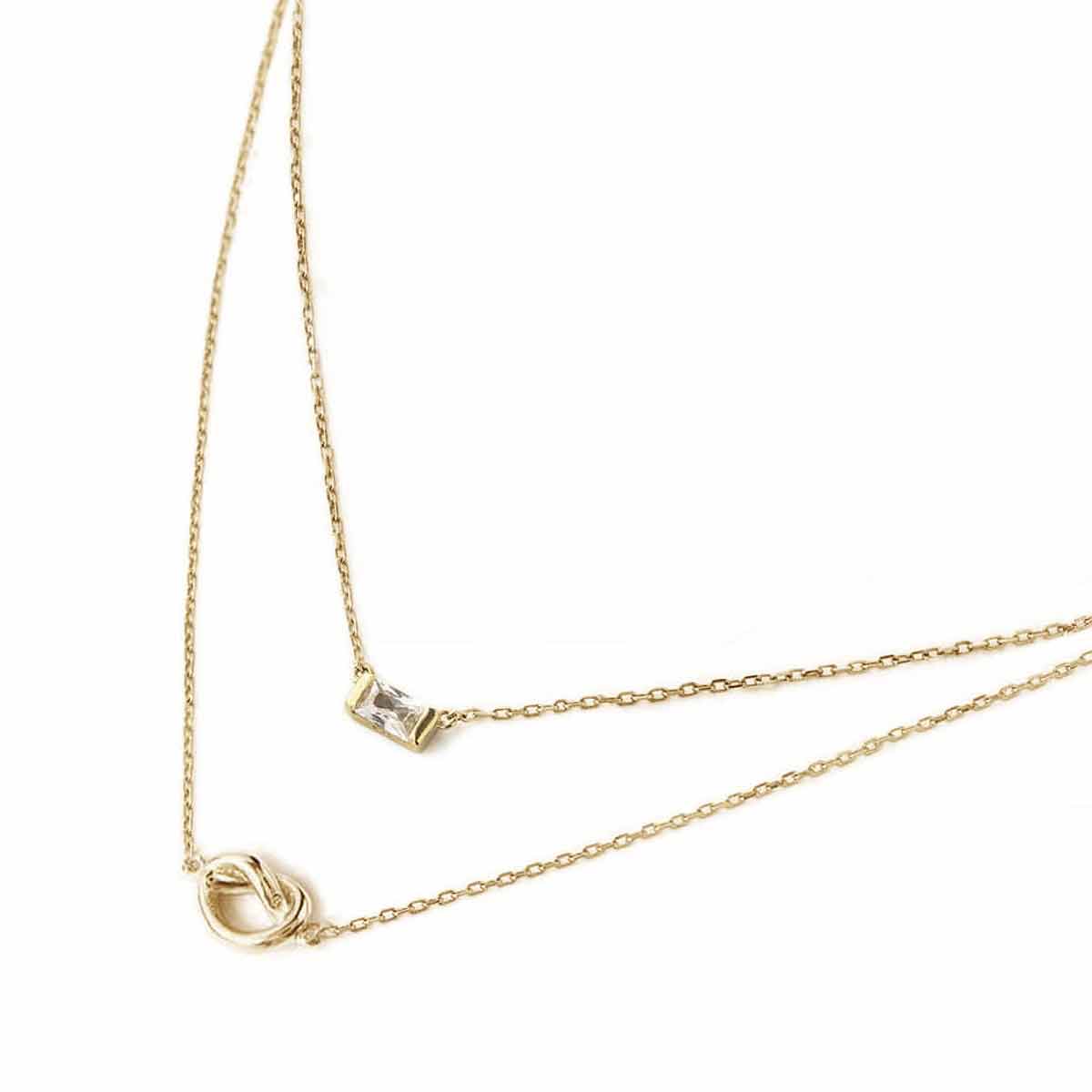 Gold vermeil baguette white zirconia pendant and loveknot necklace duo, close-up on a white background