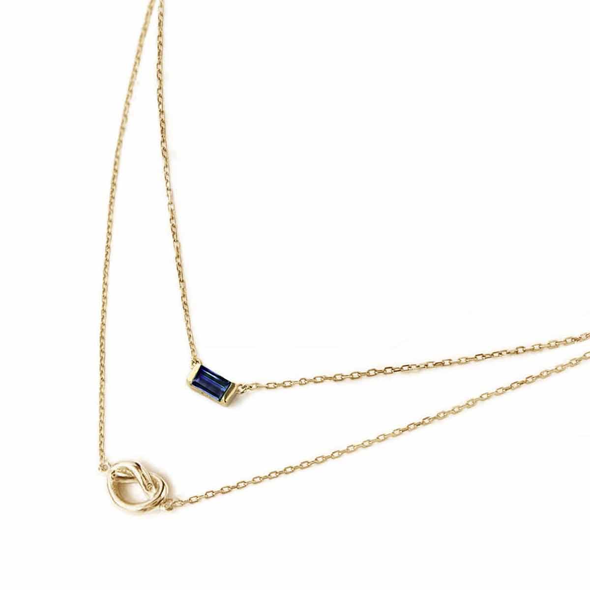 Gold vermeil layered duo necklace with a blue baguette stone and a knot, on a white background