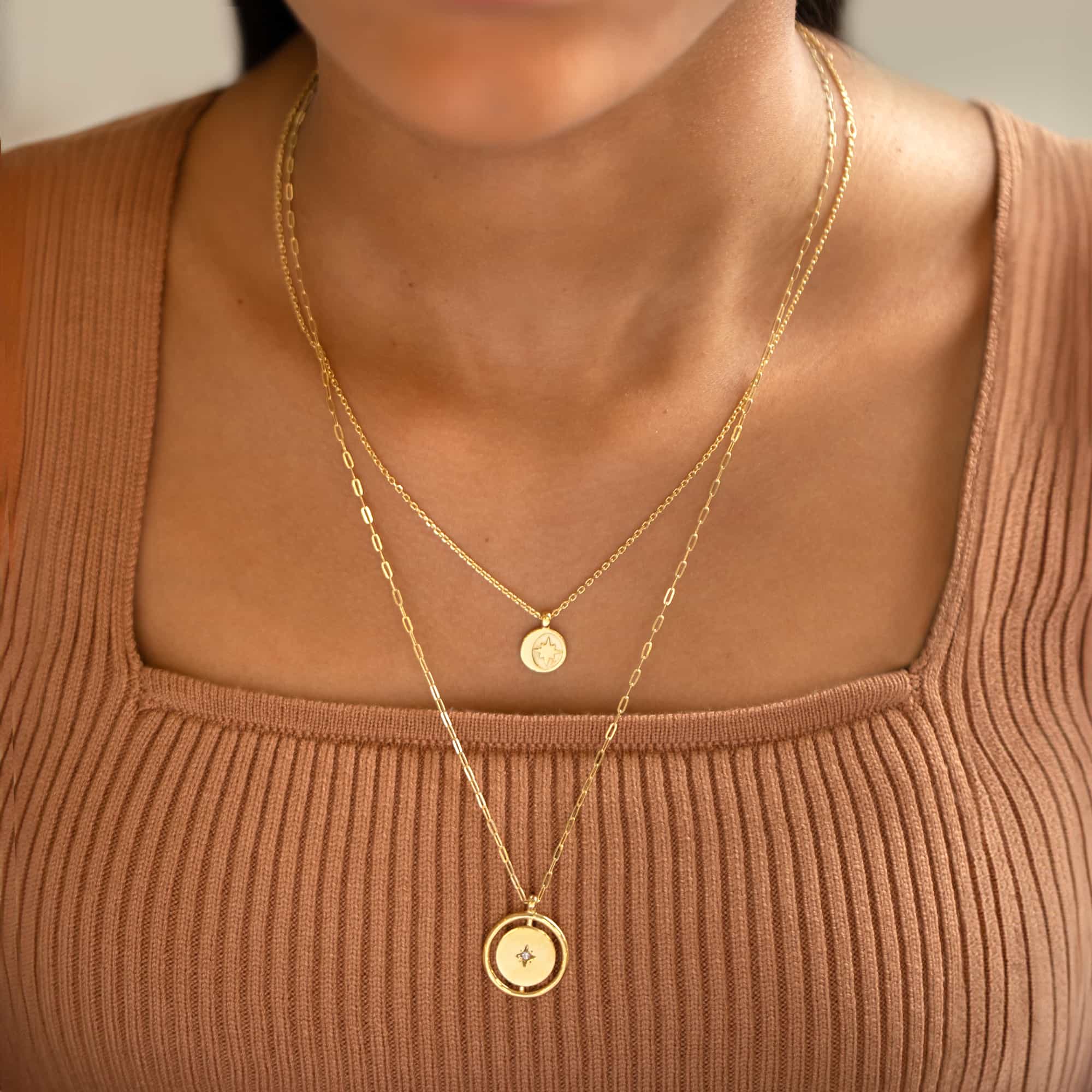 Gold vermeil Northern Star disc pendant on a paperclip chain, shown layered on a model's chest