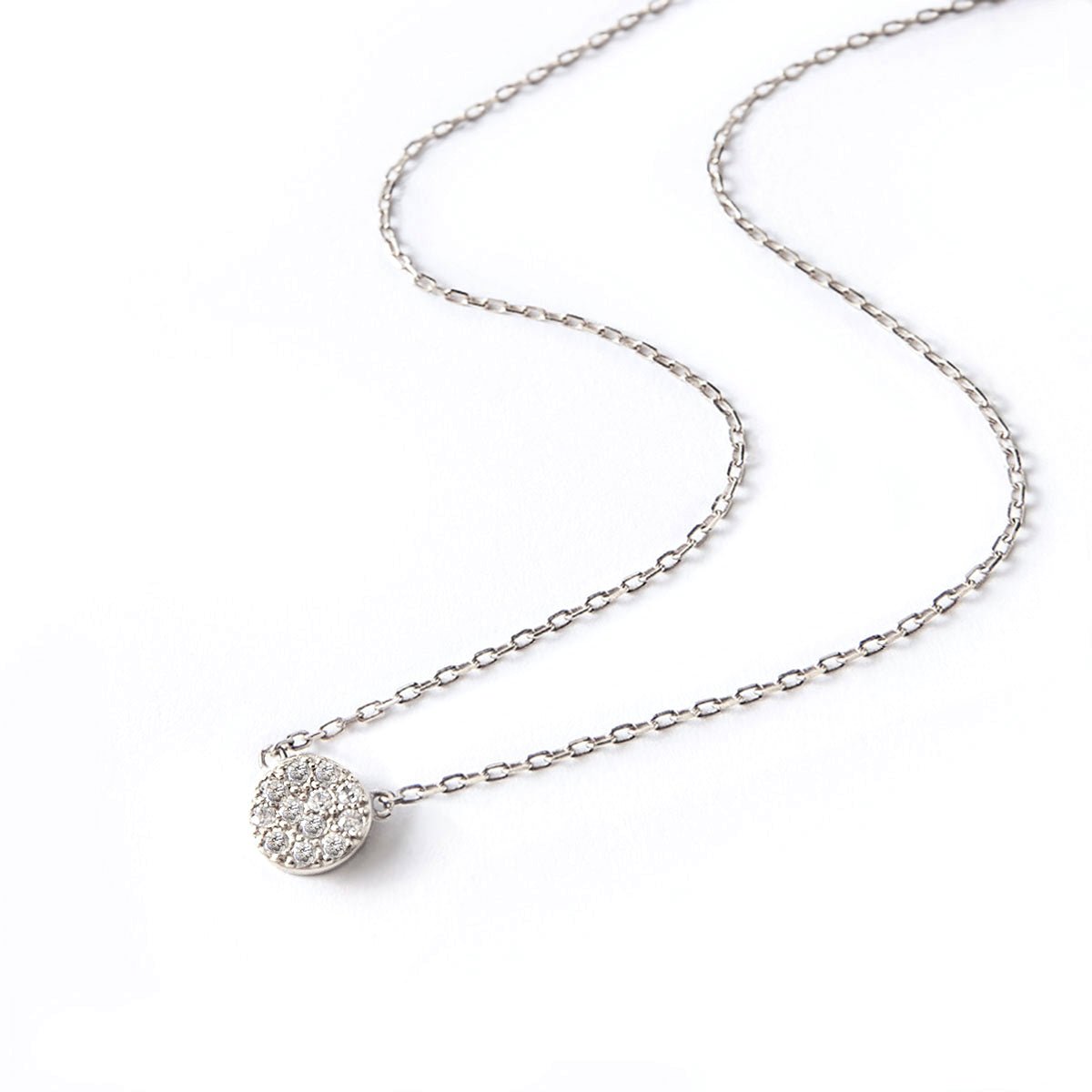 Sterling silver white zirconia pavé disc pendant on a fine chain, on a white background