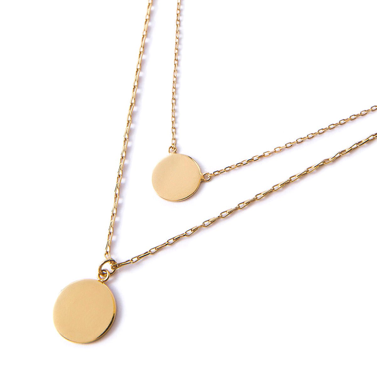Gold vermeil layered necklace duo with two plain round discs on fine chains, on a white background