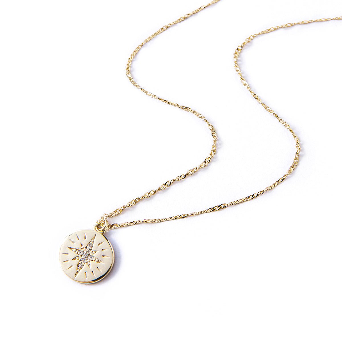 Gold vermeil star disc necklace with a white zirconia starburst pendant, on a white background