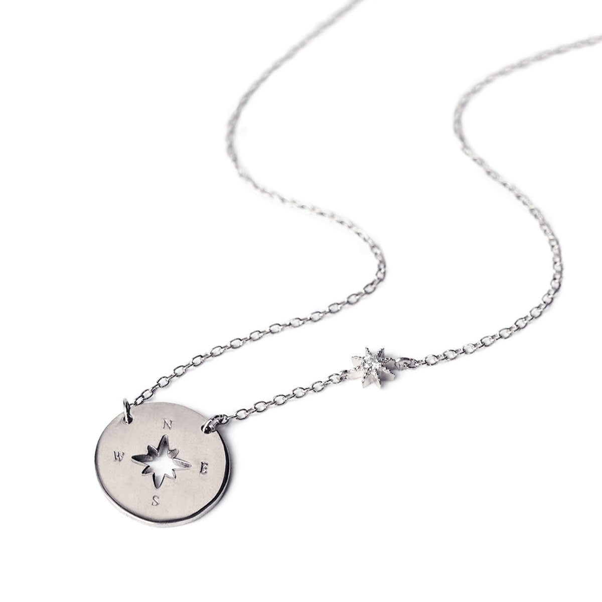 Sterling silver compass disc necklace with a star cutout and clear stone station, on a white background