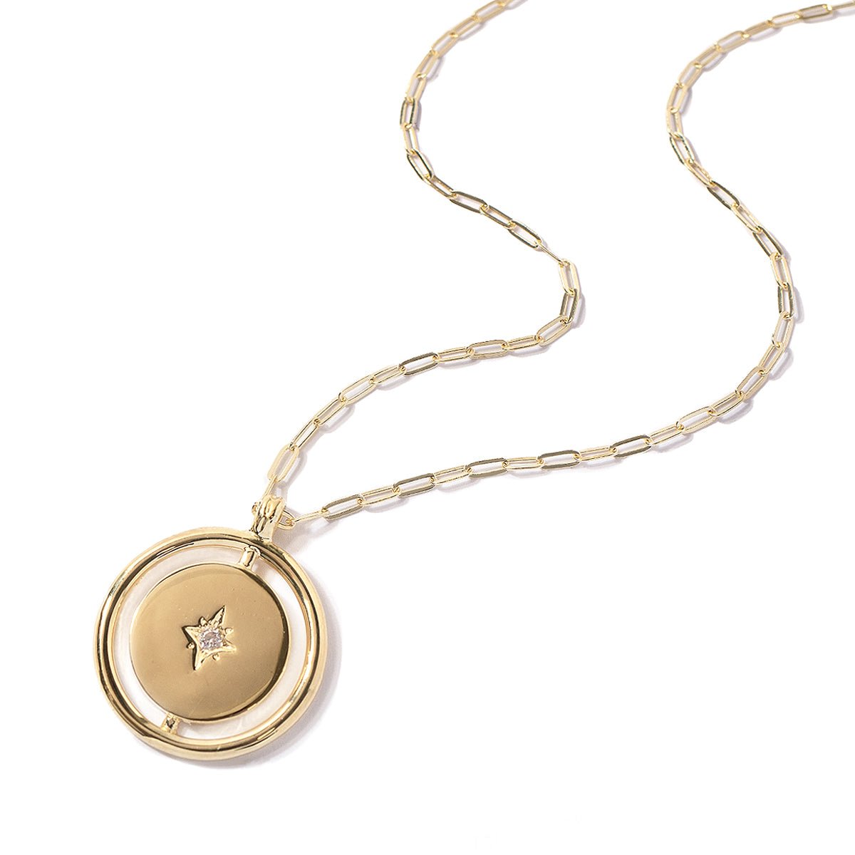 Gold vermeil Northern Star disc pendant with a center star and clear stone on a paperclip chain, on a white background