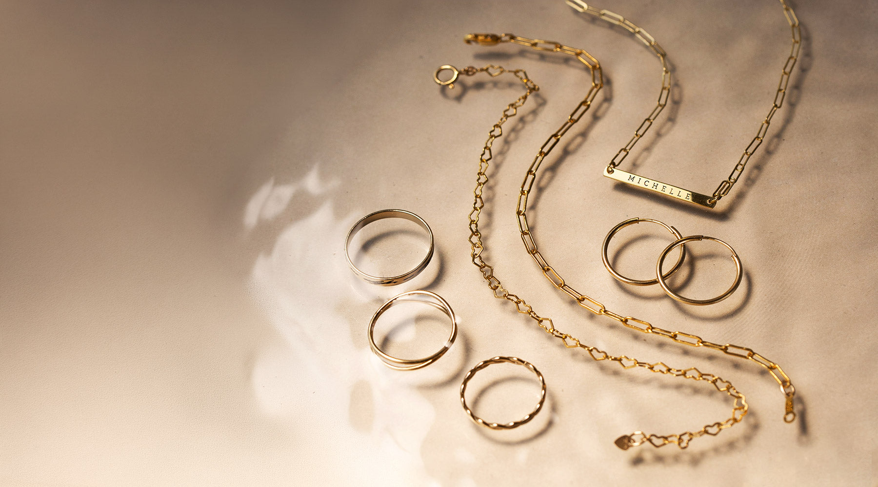 AMYO waterproof jewelry featuring gold necklaces, bracelets, rings, and hoop earrings designed for everyday wear.