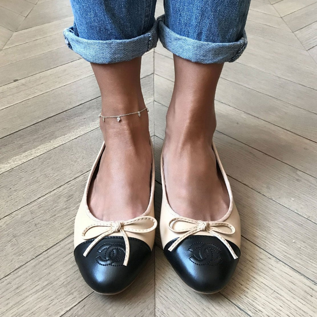 Sterling silver clover anklet with clear stones, shown on a model's ankle with two-tone ballet flats