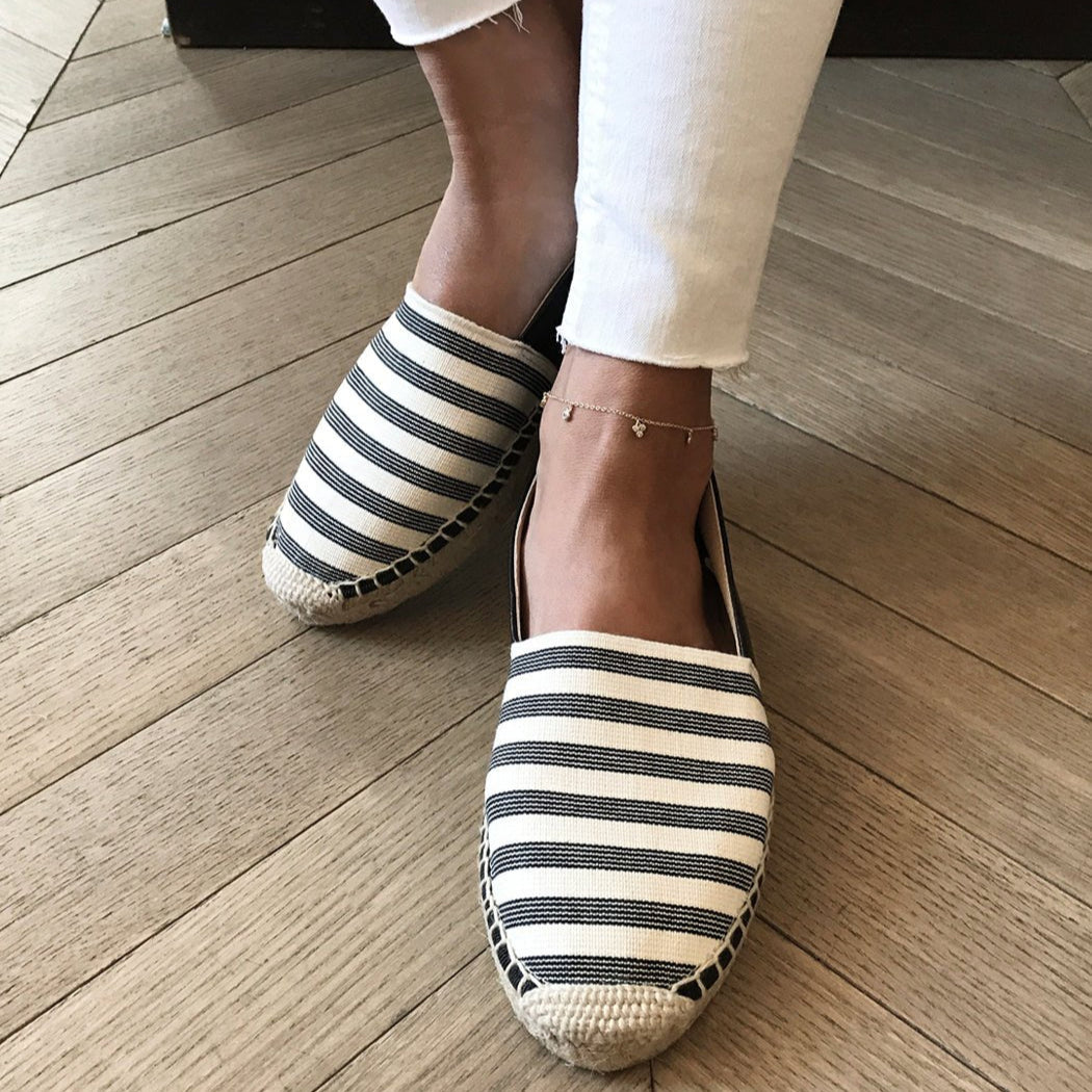 Gold vermeil clover anklet with tiny clear stones, shown on a model's ankle with striped espadrilles