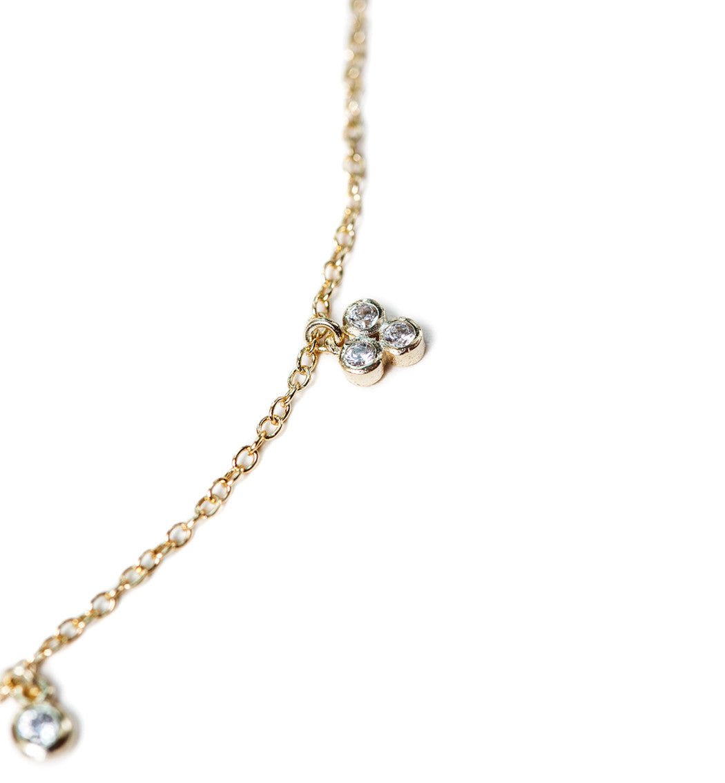 Close-up detail of the gold vermeil clover crystal anklet's clustered clear stones