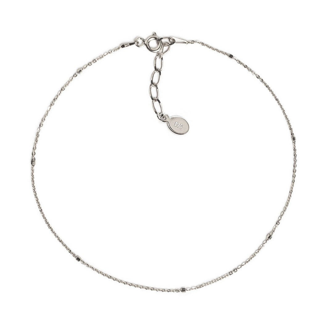 Sterling silver dainty beaded anklet chain with a spring-ring clasp, laid on a white background