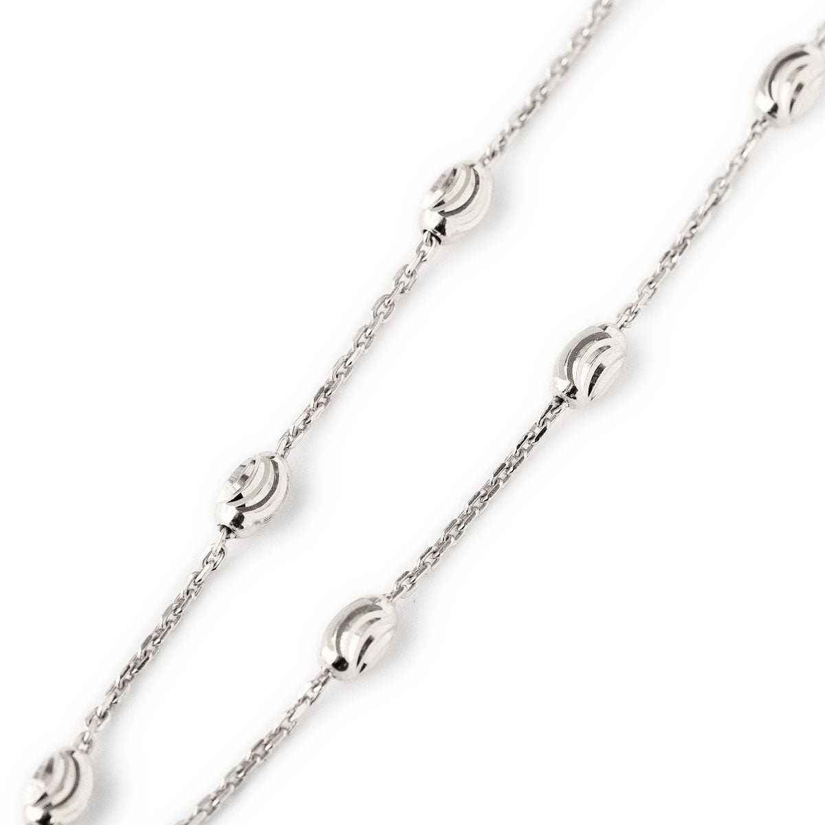 Sterling silver beaded station anklet chain with faceted oval beads, close-up detail on a white background