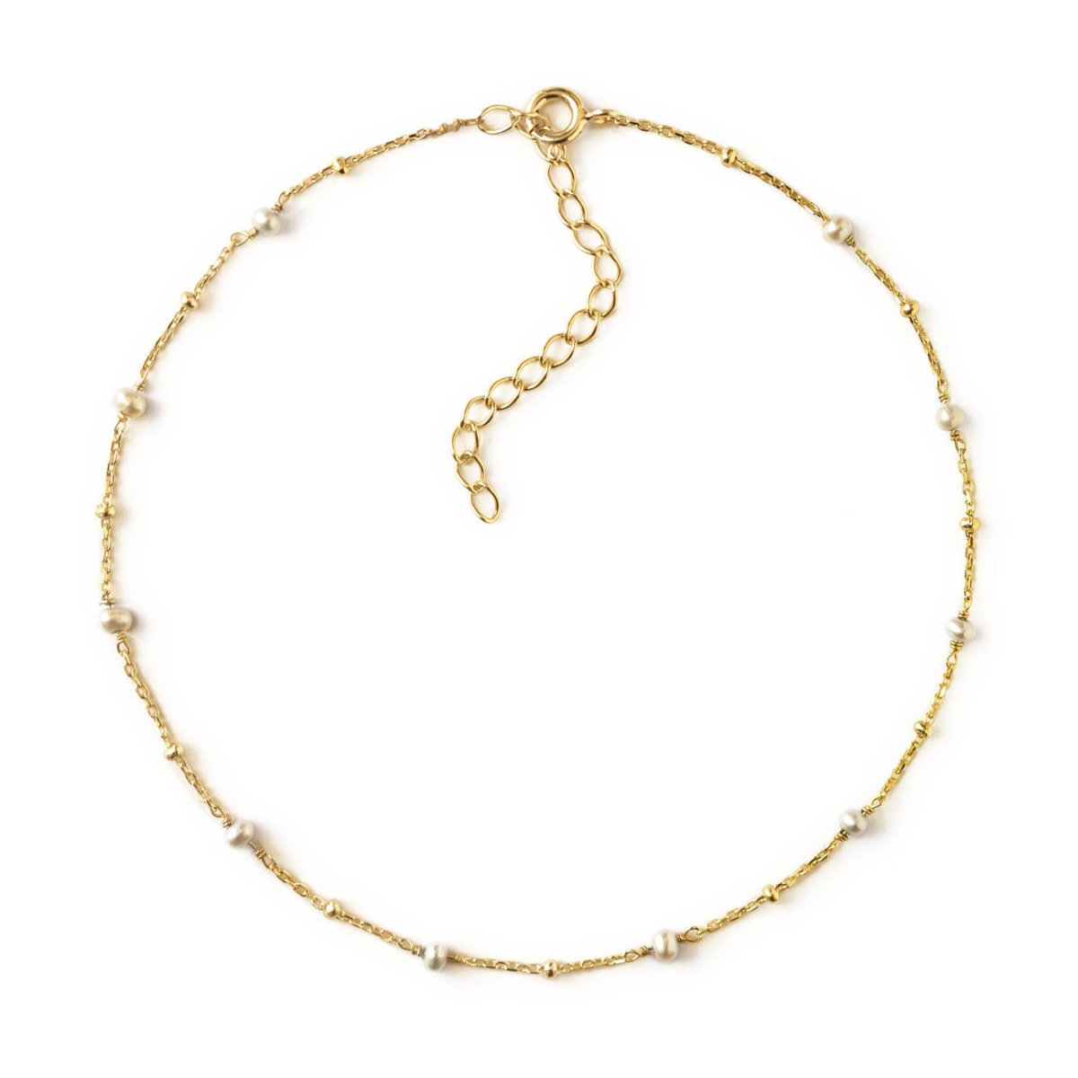 Gold vermeil beaded chain anklet with small pearl stations, laid in a circle on a white background