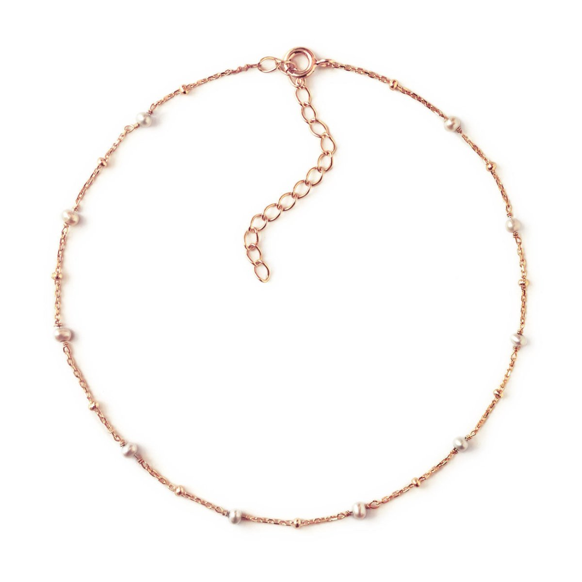 Rose gold vermeil beaded chain anklet with small pearl stations, laid in a circle on a white background
