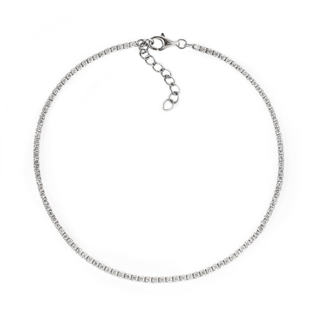 Sterling silver anklet with a row of small clear stones and an extender chain, on a white background