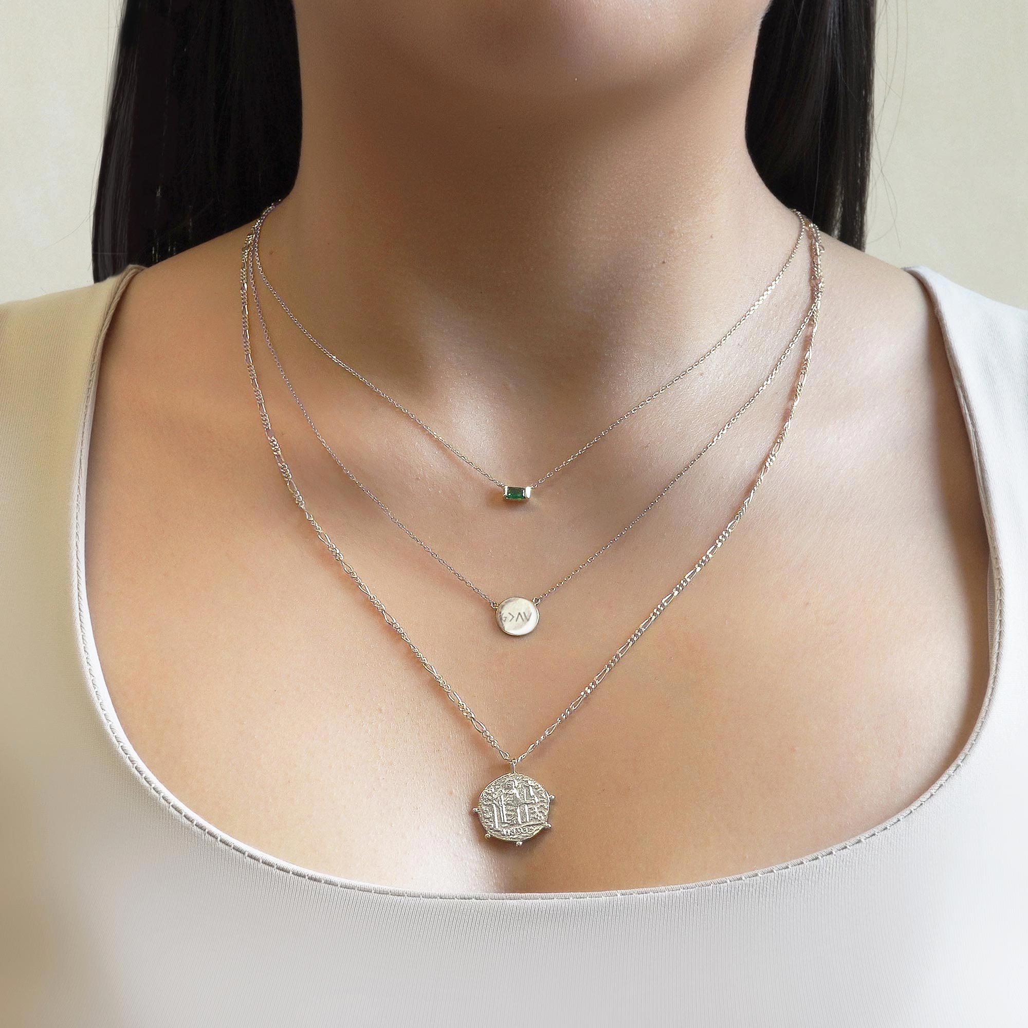 Sterling silver engravable disc necklace layered with two chains, shown on a model's neckline