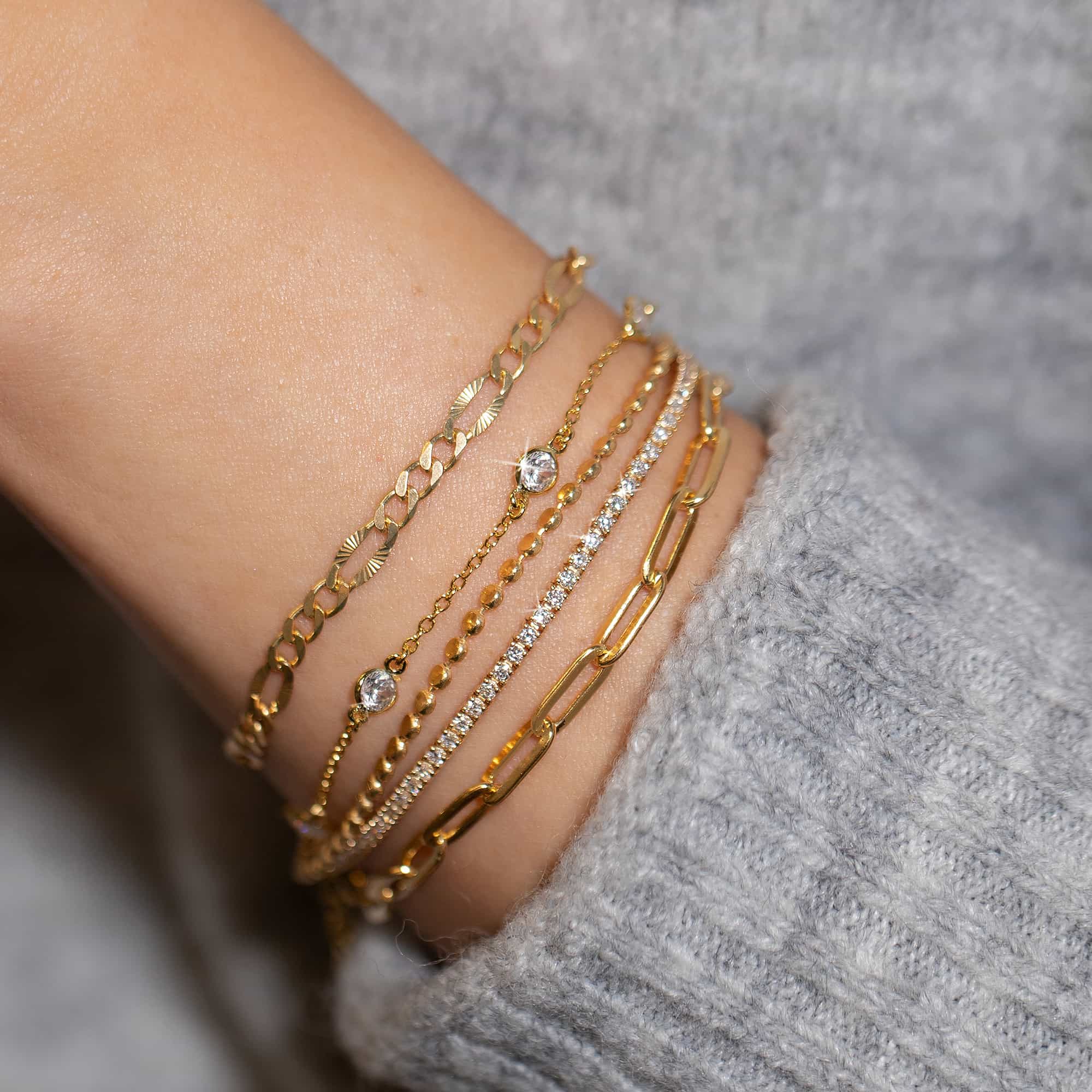 Gold vermeil beaded chain bracelet shown stacked with other chains on a model's wrist