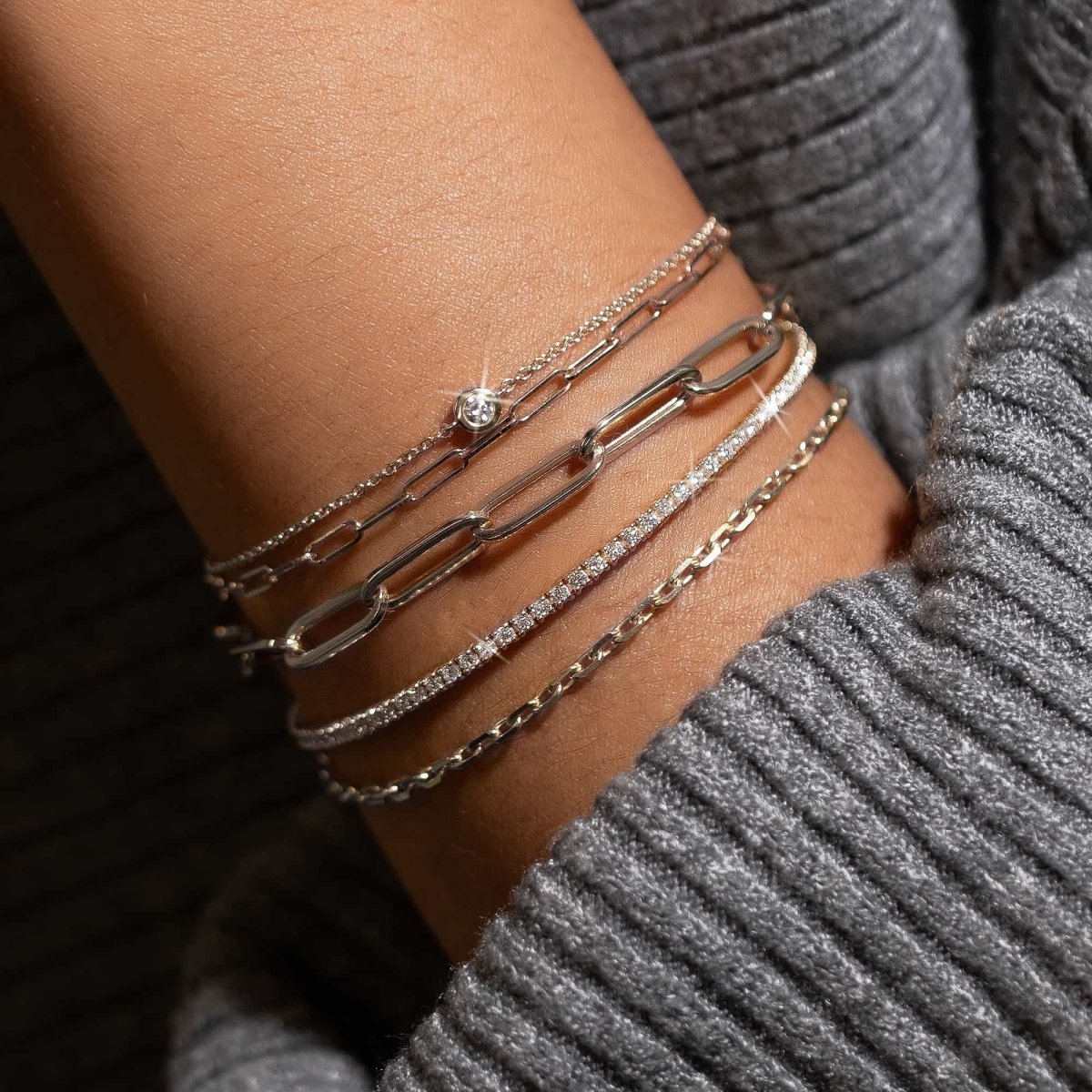 Sterling silver crystal tennis bracelet with white zirconia stones, shown stacked on a model's wrist