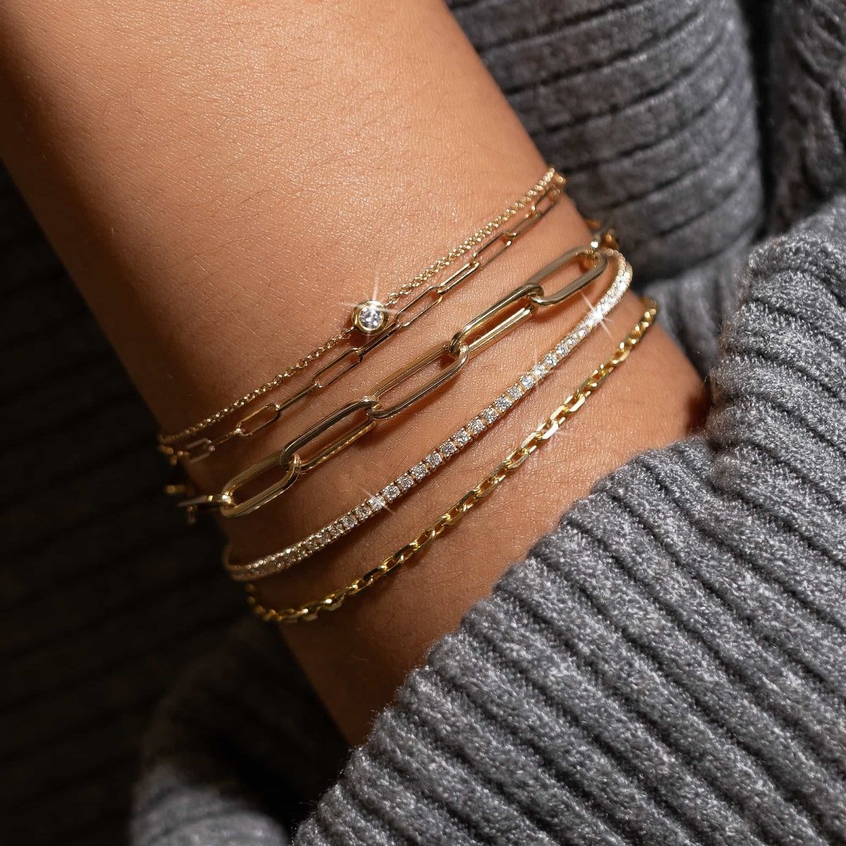 Gold vermeil crystal tennis bracelet with white zirconia stones, stacked on a model's gold wrist stack