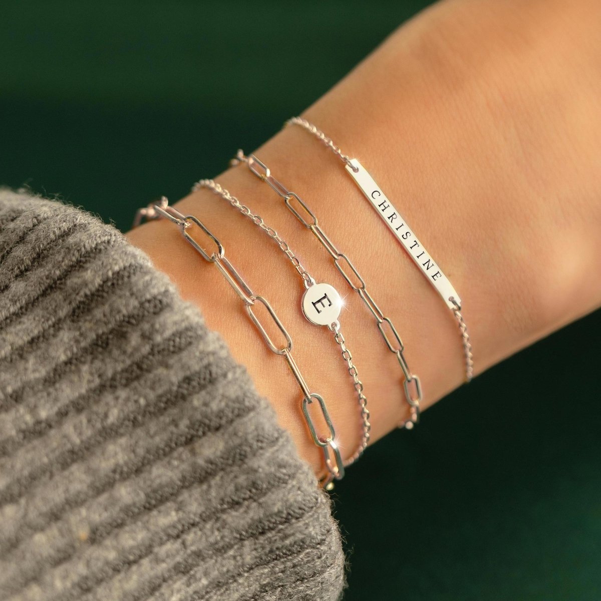 14K white gold paperclip chain bracelet stacked in a layered wrist look on a model