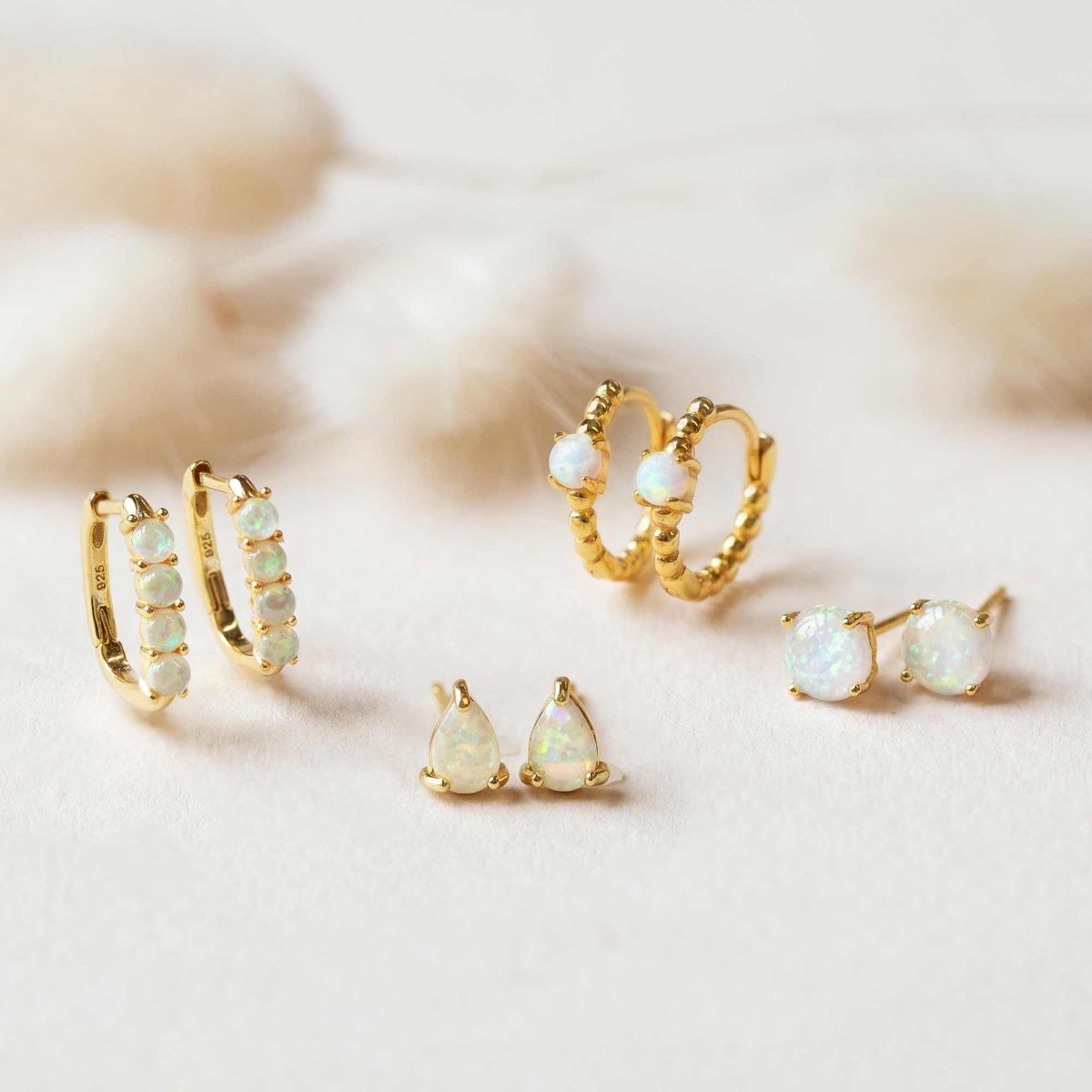 Gold vermeil solitaire opal stud earrings with white opal stones, styled with matching pieces