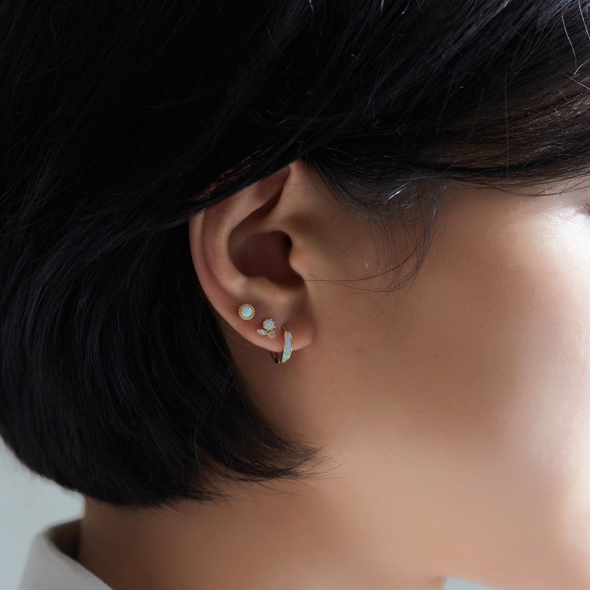 14K gold beaded opal flat back stud shown on a model's lobe in an ear stack