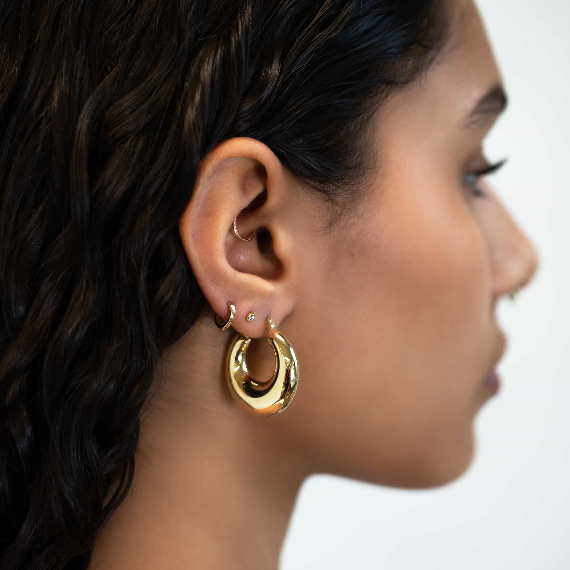 14K gold chunky bubble hoop earring shown on a model's lobe in profile
