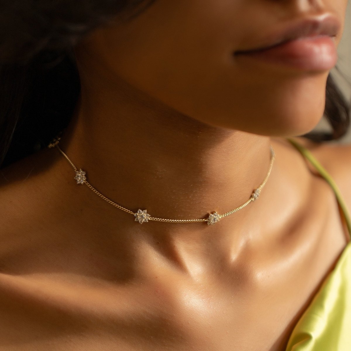 Gold vermeil white zirconia choker with pavé flower stations, shown on a model's neck