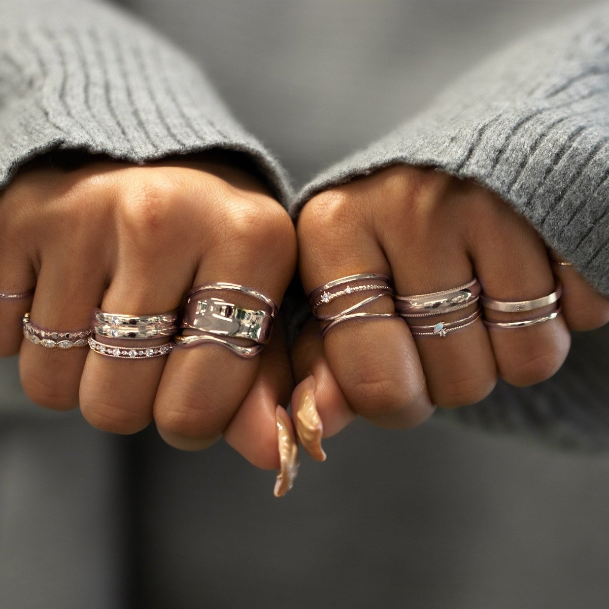 Gold vermeil melted wide statement ring with a stone-set band, shown on a model's hand near the face