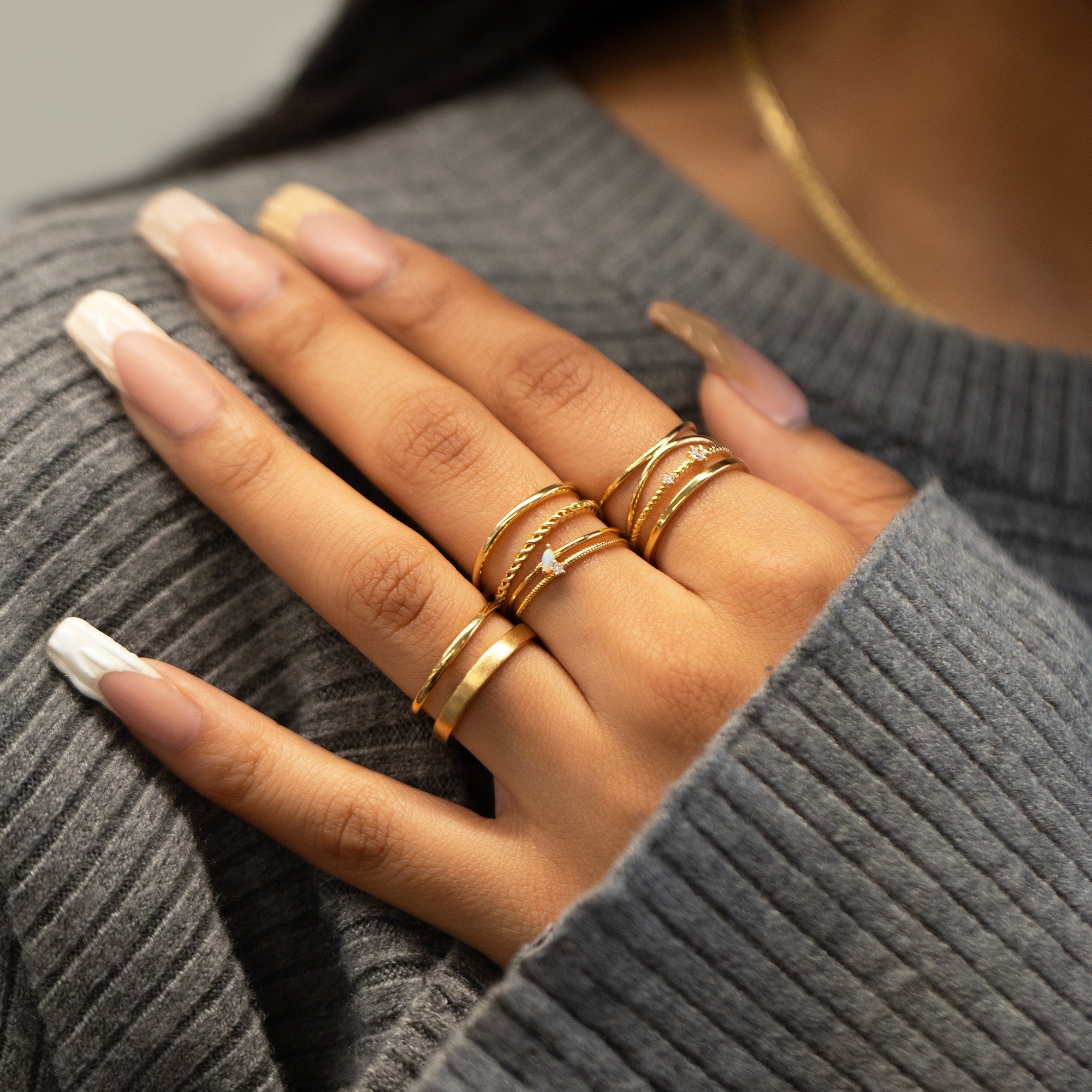 Gold vermeil rope-twist double-band stacking ring layered with other rings on a model's hand